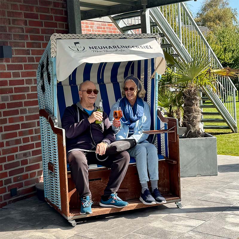 Paar genießt die Sonne im blau-weißen Strandkorb